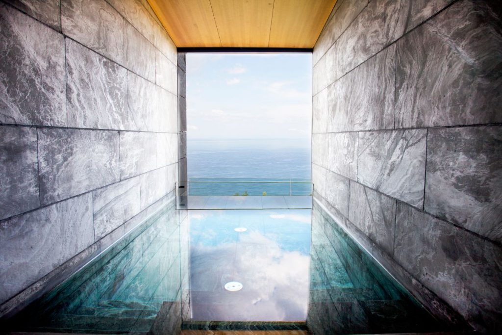 Natural stone spa with infinity pool and seamless glass wall opening to Cantabrian Sea views, Akelarre Hotel